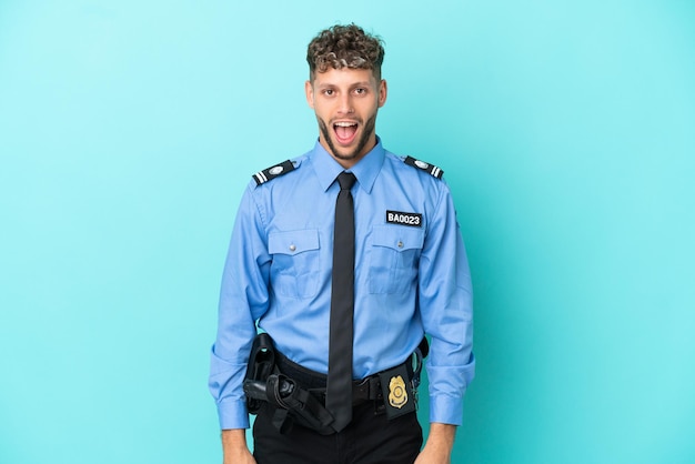 Junger blonder mann der polizei isoliert weiß auf blauem hintergrund mit überraschtem gesichtsausdruck