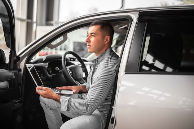 Junger eleganter Mann, der ein Auto prüft