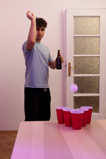 Kostenloses Foto junger erwachsener, der bierpong spielt