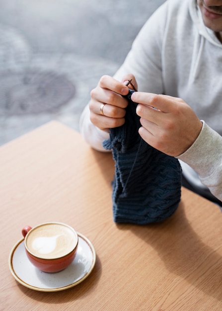 Junger Erwachsener, der draußen strickt