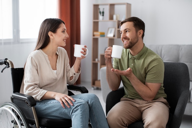 Kostenloses Foto junger erwachsener, der kaffee mit behindertem freund trinkt