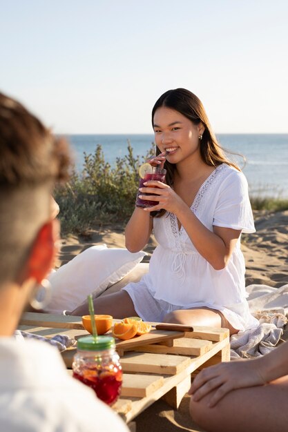 Junger Erwachsener mit einer Sangria-Party am Strand