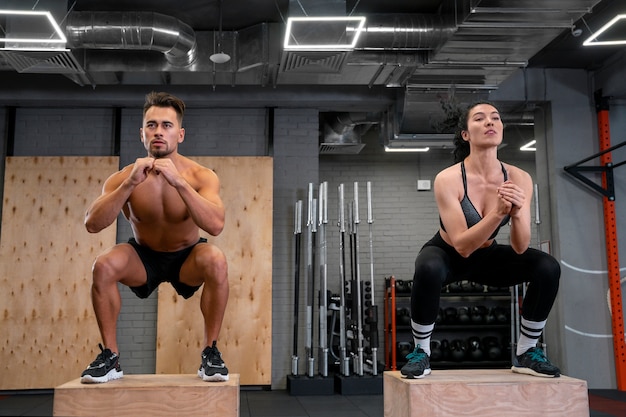 Kostenloses Foto junger fitter mann und frau, die zusammen im fitnessstudio trainieren