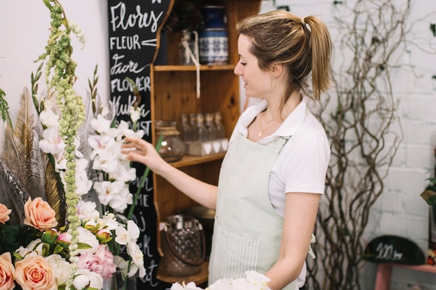 Junger Florist, der im Blumenladen arbeitet