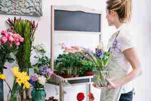 Kostenloses Foto junger florist, der um blumen sich kümmert