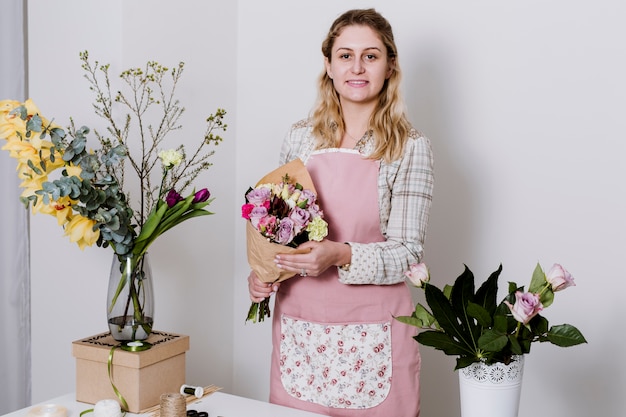 Kostenloses Foto junger florist mit blumenstrauß von schönen blumen