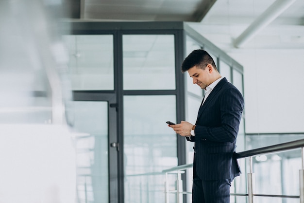 Junger Geschäftsmann, der am Telefon im Büro spricht