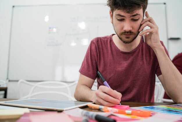 Junger Geschäftsmann, der am Telefon spricht