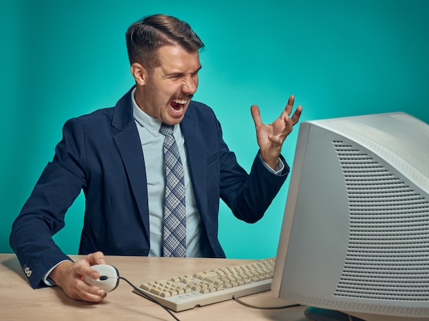 Junger Geschäftsmann, der Computer im Büro benutzt