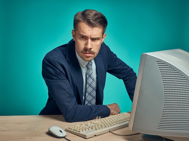 Kostenloses Foto junger geschäftsmann, der computer im büro benutzt