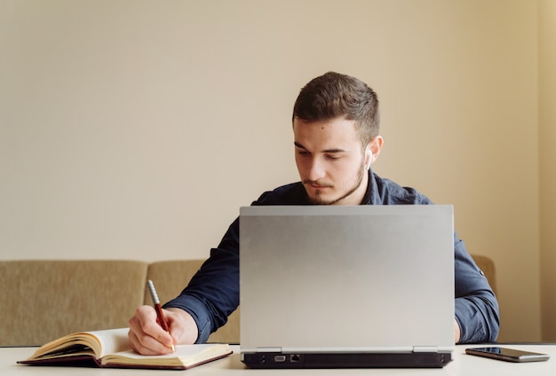 Junger Geschäftsmann, der mit Computer entfernt arbeitet