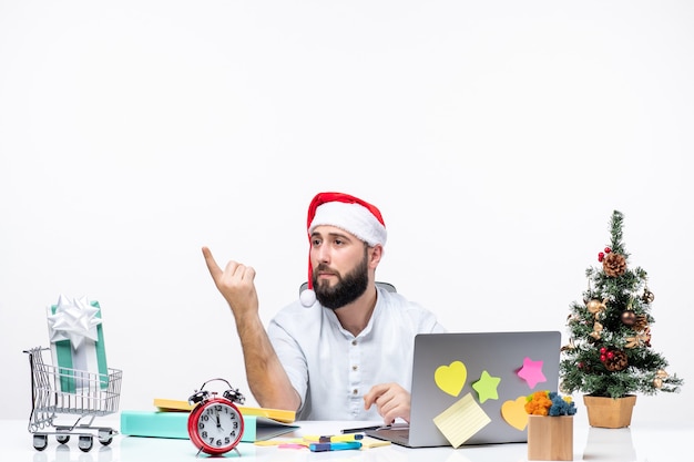 Junger Geschäftsmann im Büro, der Weihnachten feiert, alleine arbeitet und jemanden anruft