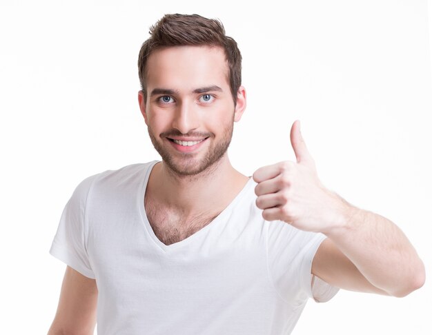 Junger glücklicher Mann mit Daumen hoch Zeichen in Casuals lokalisiert auf weißem Hintergrund.