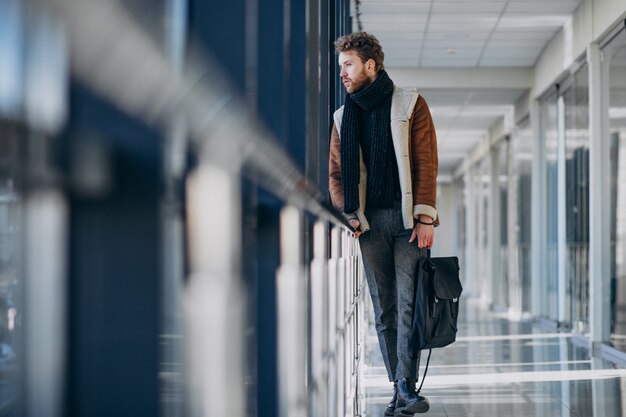 Junger gutaussehender Mann, der mit Tasche reist