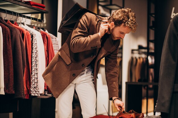 Junger gutaussehender Mann, der Stoff am Shop wählt