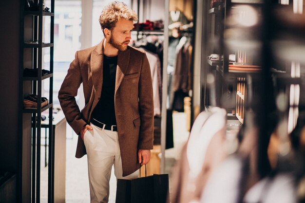 Junger gutaussehender Mann, der Stoff am Shop wählt