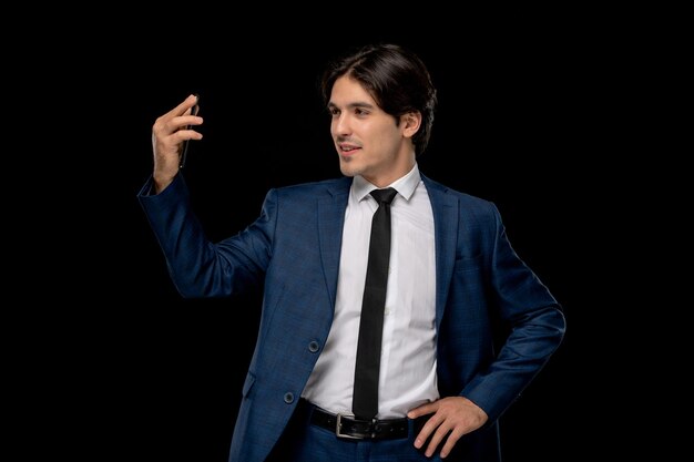 Junger gutaussehender Mann des Geschäftsmannes im dunkelblauen Anzug mit der Krawatte, die auf Videoanruf spricht