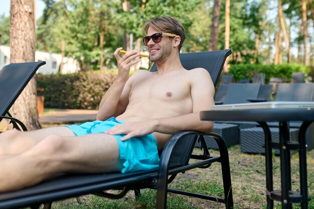 Junger gutaussehender Mann mit einem Telefon in der Hand