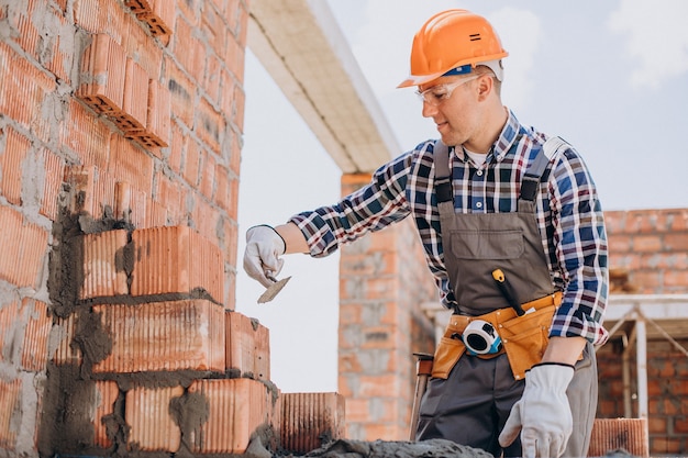 Junger Handwerker, der ein Haus baut