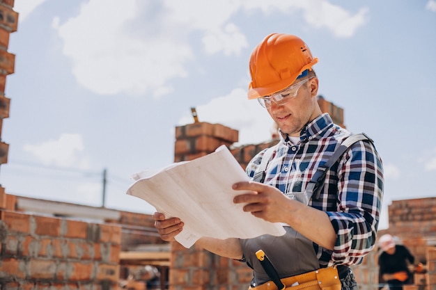 Junger Handwerker, der ein Haus baut