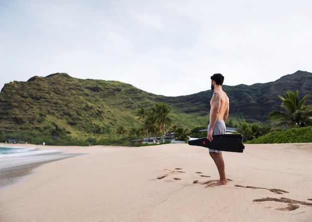 Kostenloses Foto junger hemdloser mann am strand mit tauchausrüstung