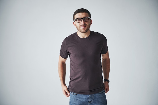 Junger Hipster-Typ, der eine Brille trägt, die glücklich lokalisiert auf Weiß lacht
