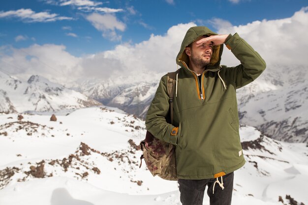 Junger Hipstermann, der in den Bergen wandert, Winterferienreisen