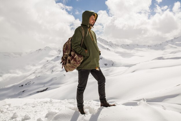 Junger Hipstermann, der in den Bergen wandert, Winterferienreisen