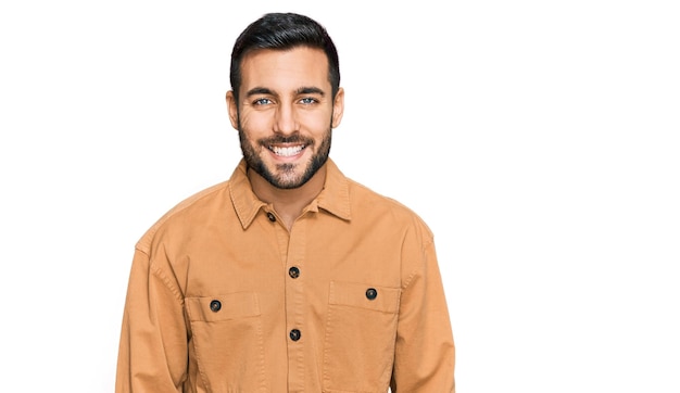 Kostenloses Foto junger hispanischer mann in lässiger kleidung mit einem glücklichen und kühlen lächeln im gesicht, glücklicher mensch