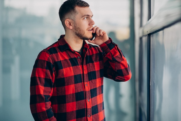 Junger hübscher Mann, der Telefon benutzt