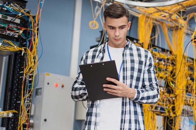 Kostenloses Foto junger ingenieur im mittleren schuss des serverraumes