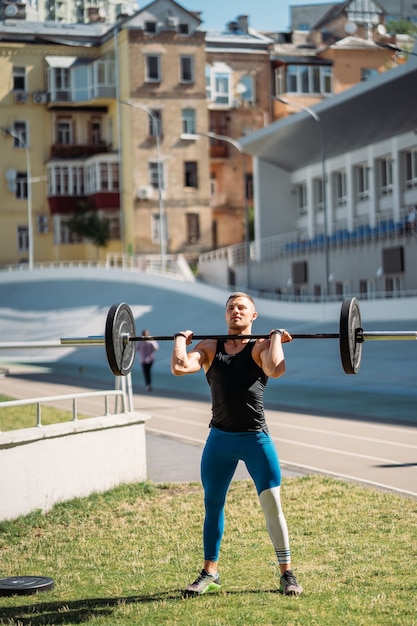 Junger Kerl legt die Messlatte im Stadion höher, Outdoor-Training