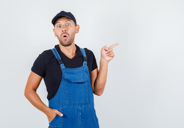 Junger Lader, der in Uniform zur Seite zeigt und ängstlich aussieht, Vorderansicht.