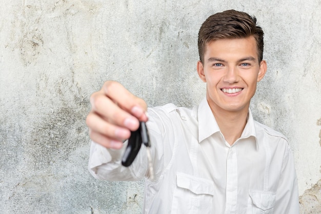 Kostenloses Foto junger lächelnder mann mit autoschlüssel