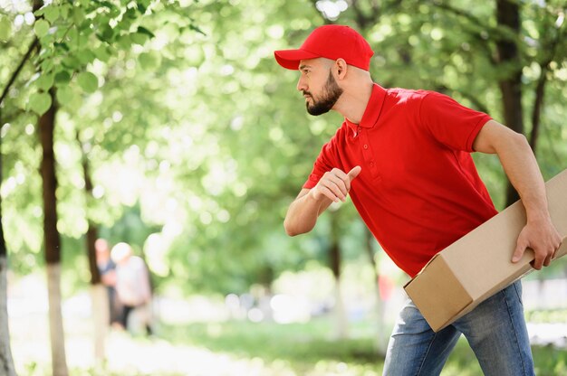 Junger Lieferbote, der Karton trägt