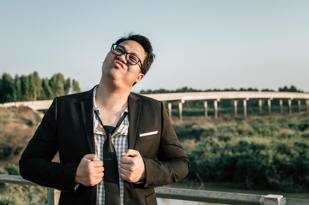 Junger lustiger asiatischer Geschäftsmann, der Hemd und Krawatte mit Shorts und Brille in verrückter und lustiger Weise trägt, kopieren Raum
