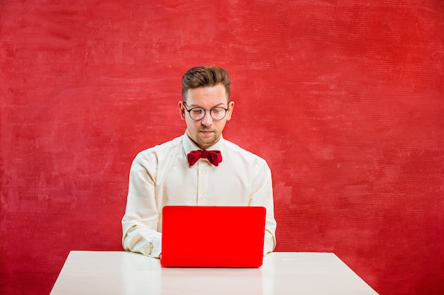 Junger lustiger Mann mit Laptop am Valentinstag