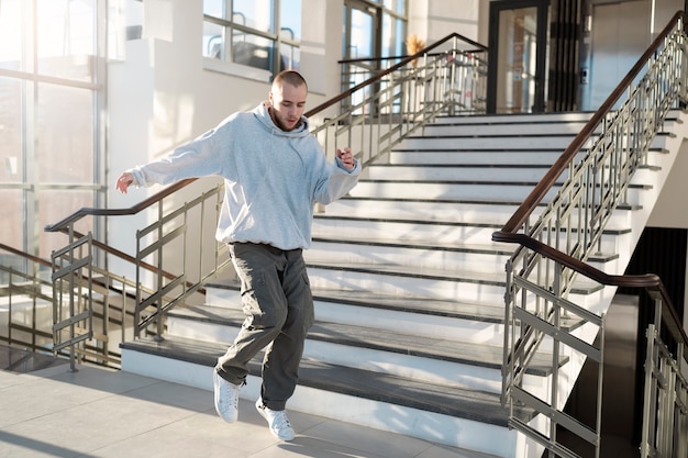 Junger männlicher Darsteller tanzt in einem Gebäude neben der Treppe