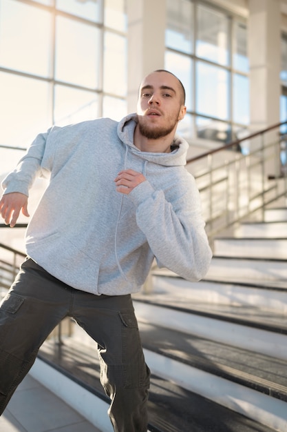 Junger männlicher Darsteller tanzt in einem Gebäude neben der Treppe