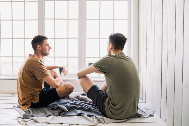 Junger männlicher Freund, der mit Morgenkaffee spricht