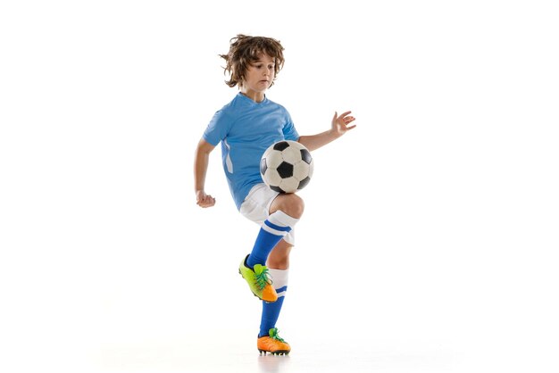 Junger männlicher Fußballspieler Junge trainiert mit Fußballball isoliert auf weißem Studiohintergrund Konzept des Sportspiel-Hobbys