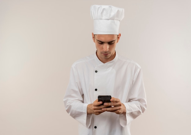 Junger männlicher Koch, der die einheitliche Wählnummer des Kochs am Telefon mit Kopienraum trägt