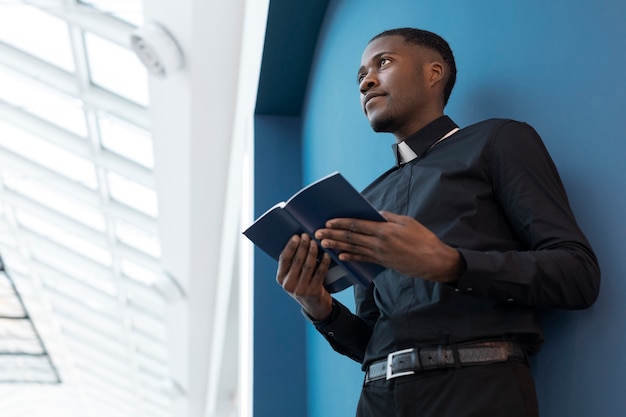 Junger männlicher Priester, der Buch hält