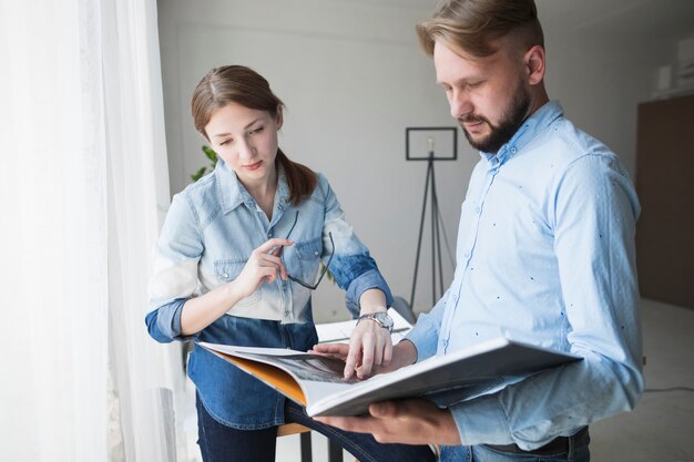 Junger männlicher und weiblicher Architekt, der im Büro arbeitet