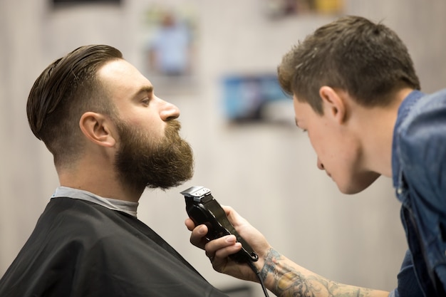 Junger Mann bekommt Bart Grooming am Friseursalon
