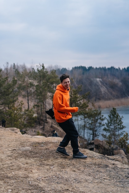 Junger Mann, der am Rand einer Klippe steht