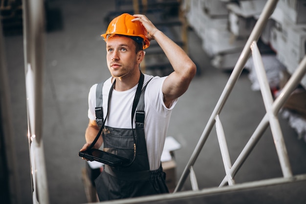 Junger Mann, der an einem Lager mit Kästen arbeitet