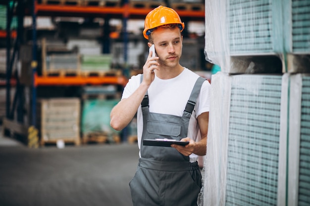 Junger Mann, der an einem Lager mit Kästen arbeitet