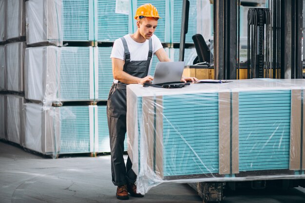 Junger Mann, der an einem Lager mit Kästen arbeitet