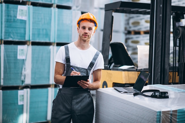 Junger Mann, der an einem Lager mit Kästen arbeitet